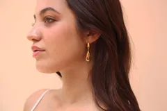 Par de pendientes colgantes dorados con diseño de lágrima.