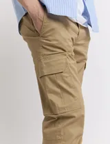 Pantalón de gabardina verde militar, corte cargo con bolsillos laterales con fuelle y tobillos ajustados con elástico.