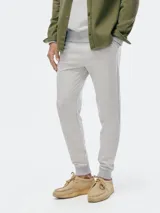 Pantalón tipo babucha de color azul oscuro, confeccionado con interior de felpa. Presenta cintura elástica con cordón de ajuste y puños acanalados en los tobillos.