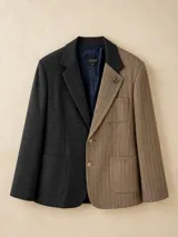 Blazer de diseño bicolor con silueta oversize. El lado derecho presenta un tejido tweed en color gris oscuro, mientras que el lado izquierdo combina un tejido tweed a rayas en tonos marrones. Cuenta con solapas clásicas, cierre frontal de dos botones y bolsillos frontales. Incluye un pin decorativo metálico en forma de perro salchicha en la solapa.