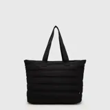 Tote bag acolchada de color azul marino, con diseño de costuras horizontales, doble asa superior y bolsillo frontal con cierre. Incluye compartimento interno para laptop.