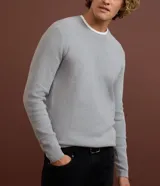 Suéter de punto para hombre, color celeste, con textura acanalada horizontal, cuello redondo y mangas largas con puños ajustados.