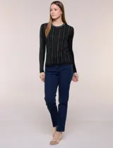 Blusa de punto acanalado fino, color negro, con ajuste al cuerpo, escote a la base y mangas largas. Cuenta con apliques de strass dispuestos en líneas verticales paralelas en el frente y las mangas, además de una vista decorada con estrás brillantes en el escote.