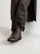 Bota corta de cuero color marrón con punta cuadrada y suela plana de goma negra.