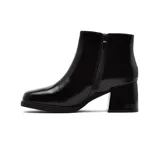 Bota corta de charol negro con cierre lateral, caña baja y taco cuadrado. Diseño elegante y moderno.