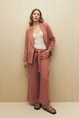 Pantalón de tiro alto color ladrillo, de corte ancho y con cinturón de la misma tela.