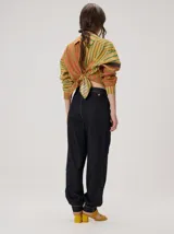 Pantalón tipo bombacha de campo color beige, de corte holgado con pinzas en la cintura y puños ajustados en los tobillos. Presenta costuras a contratono y bolsillos laterales.