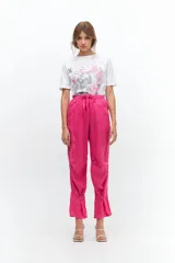 Pantalón de lino color fucsia, de corte relajado con cintura elástica y lazo ajustable. Presenta bolsillos ojal y detalle de presillas con botones en los tobillos que permiten ajustar el ruedo.