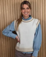 Chaleco de punto color blanco crudo con detalles en tono tostado en el cuello redondo, sisas y dobladillo inferior, confeccionado en algodón.