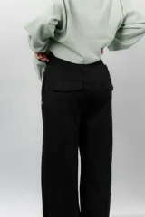 Pantalón blanco de silueta amplia y caída fluida, con cintura alta elastizada y lazo regulable con terminaciones metálicas.