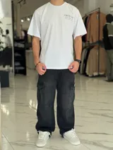 Remera oversize color beige, con diseño estampado en la espalda que incluye tipografía grande y texto descriptivo en negro.