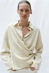 Camisa de rayas con cuello solapa y manga larga, con diseño cruzado en el frente y cierre de botones.