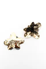 Aros grandes en forma de flor con pétalos metalizados en tono dorado y detalles de tela negra.