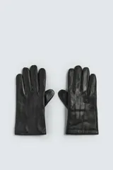 Guantes de cuero negro con interior forrado en tejido de punto. Presentan costuras decorativas en el dorso y tecnología táctil en los dedos para el uso de dispositivos móviles.