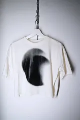 Remera blanca de corte holgado con estampa frontal abstracta en degradado negro.