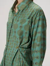 Camisa de algodón con estampado geométrico de ondas en tonos marrón y negro, corte holgado, mangas largas y cuello clásico.