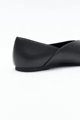 Zapato bajo de mujer, color negro, con punta fina y escote pronunciado en forma de V en el empeine. Presenta un acabado liso y una suela baja y plana.