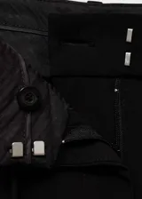 Pantalon de vestir negro de corte recto y tiro medio, con trabillas en la cintura, cierre oculto y lazo ajustable. Cuenta con bolsillos laterales y forro interior.