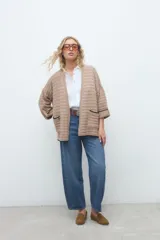 Kimono de tejido de punto en color beige, con diseño abierto al frente, mangas tres cuartos y bolsillos aplicados con ribete oscuro.