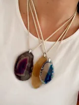 Collar con cordón de símil gamuza y dije de piedra ágata natural en forma irregular con terminaciones metálicas plateadas.