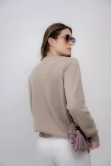Sweater color beige de cashmere con escote en V y mangas largas.