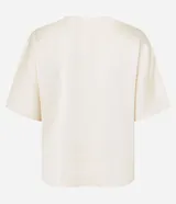 Blusa celeste de tejido satinado con cuello redondo, pliegues en el cuello y manga corta.