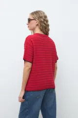 Remera de punto color rojo con mangas cortas, cuello redondo y finos ribetes oscuros en el cuello y puños.