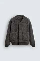 Cárdigan de corte relajado confeccionado en tejido con textura efecto pelo. Presenta cuello en pico, manga larga, cierre frontal con botones y bolsillos delanteros tipo plastrón. Los puños y el bajo cuentan con acabado en rib.
