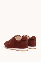 Zapatilla de gamuza color bordó con cordones bicolores, interior de cuero vacuno y suela de caucho blanca y beige.