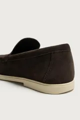 Mocasín casual para hombre confeccionado en piel con acabado en serraje, color marrón, con horma redonda, detalle de bordón y suela a contraste en tono claro.