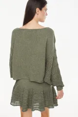 Sweater cropped de punto calado, color celeste melange, con mangas anchas de diseño holgado y cuello redondo.
