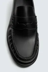 Mocasín de vestir fabricado en piel color bordó, con detalle de antifaz en el empeine y suela a tono con ligero tacón.