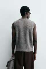 Chaleco de punto con acabado cepillado de textura suave y peluda. Presenta un diseño de corte holgado, cuello en pico y manga sisa.