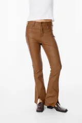 Pantalón de ecocuero color marrón, de corte recto con terminación ligeramente acampanada y tajos frontales en el ruedo. Cuenta con cierre y botón frontal, además de bolsillos laterales y traseros.