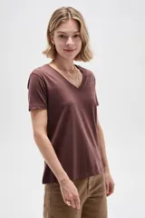 Remera marrón de manga corta con escote en V y diseño al cuerpo. Presenta un delicado detalle de tachas metálicas en forma de estampa en el hombro izquierdo.