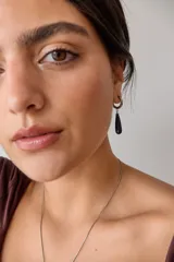 Aros colgantes de acero quirúrgico plateado con dije de piedra natural rosa en forma de lágrima.