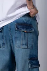 Pantalón jean cargo de corte oversize y tiro medio, con bolsillos laterales tipo cargo y costuras reforzadas en las rodillas.
