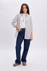 Camisa casual de manga larga con diseño de rayas verticales, cuello camisero y cierre frontal de botones.
