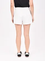 Short negro de tela de buzo, con cintura elástica ajustable con cordón y bolsillos laterales. El ruedo tiene una abertura lateral.