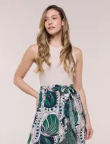 Vestido midi combinado de corte fluido. Presenta un torso ajustado acanalado sin mangas, con cuello redondo y sisas clásicas. Cuenta con cintura elastizada con lazo para anudar y falda evasé con estampado floral y geométrico, finalizando con un volante en el ruedo.