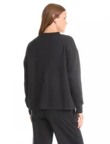 Buzo deportivo de cuello redondo, con hombros caídos y mangas largas con puños. Presenta costuras decorativas tipo pespunte en la parte frontal y en las mangas, con un diseño de ruedo recto y tajos laterales.