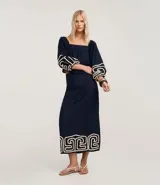 Pollera recta de largo midi en color azul marino, confeccionada en tejido de cambraia de algodón y lino. Presenta un bordado geométrico en color crema en el ruedo, cierre de cremallera y abertura central en la parte trasera.