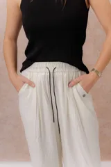 Pantalón amarillo de corte amplio y pierna recta, confeccionado en tela liviana con caída fluida. Cuenta con cintura elastizada, cordón regulable en contraste y bolsillos laterales.