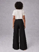 Pantalón sastrero de pierna ancha y tiro alto, con pinzas frontales y bolsillos laterales. Confeccionado en una mezcla de lino y tencel, presenta una caída fluida y estructura definida.