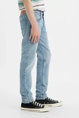 Jean de corte slim taper con tiro bajo, confeccionado en denim elástico de tono celeste claro con efecto desgastado.