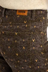 Jean flared wide leg de tiro medio con estampado geométrico en tonos marrón, verde militar y amarillo.