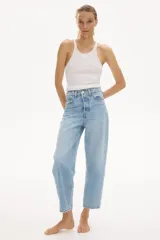 Jean barrel de tiro alto confeccionado en denim de algodón rígido, con diseño curvo y voluminoso en las piernas, largo tobillero y cinco bolsillos. Cuenta con cierre de botones en el frente.