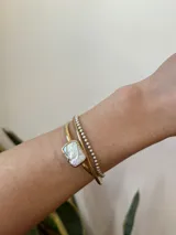 Pulsera rígida de bronce con perla de río irregular.