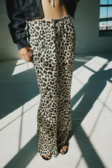 Pantalón de tiro medio con estampado animal print de leopardo, cintura elástica ajustable con cordón y perneras amplias y rectas.