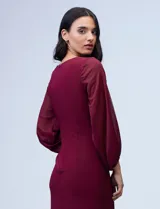 Vestido azul de RM Richards en seda fría, con escote en V cruzado, cintura drapeada, mangas largas de gasa y aplique de botones en el lateral.